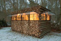 a small cabin made out of logs in the snow