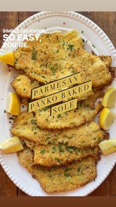 some fried food on a white plate with lemon wedges and parmesan bread