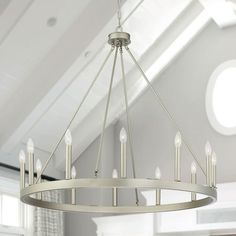 a chandelier hanging from the ceiling in a room with white walls and windows