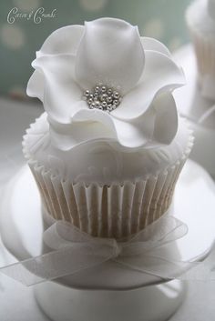 there is a cupcake with white flowers on it