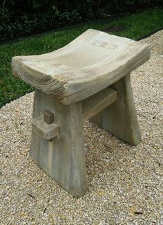 a wooden bench sitting on top of gravel