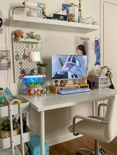 a white desk with a computer on top of it and some shelves above the desk