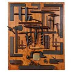 an assortment of old tools displayed on a wooden paneled surface, including hammers and wrenches