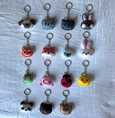 a bunch of key chains that are on a white table cloth with some animals in them