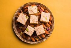 almonds, nuts and tofu on a plate with yellow wall in the background