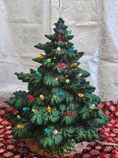 a small green christmas tree sitting on top of a table