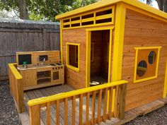 an outdoor kitchen made out of wood with yellow trim on the outside and inside walls