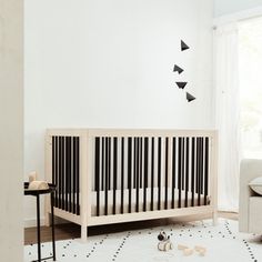 a baby crib in a white room with black and white geometric designs on the wall