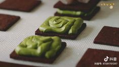 some food that is on top of a white table and has green icing on it