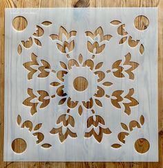 a wooden cutting board with cut out designs on it and a circular hole in the middle