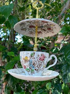 three teacups are stacked on top of each other in front of some trees