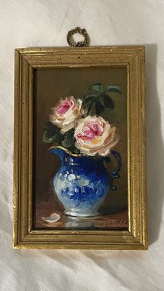 a painting of three roses in a blue vase