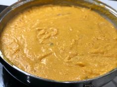 a pan filled with yellow food sitting on top of a stove