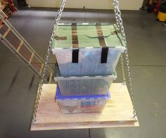 a plastic box is suspended by chains in a garage