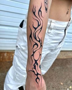 a man with a tattoo on his arm that has flames coming out of the back