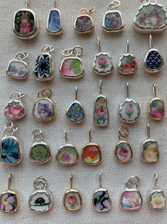 there are many different types of earrings on the table next to each other, including one with flowers