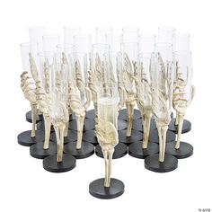 there are many wine glasses on the table with skeleton legs and bones in them, as well as champagne flutes