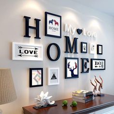 a white dresser topped with lots of pictures and framed art on the wall next to a lamp