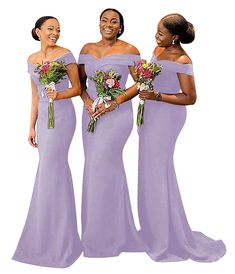 three women in long purple dresses standing next to each other and one is holding flowers