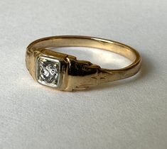 a lovely old gold ring with a fine diamond framed in white gold.  perfectly pretty, with worn art deco details.  it has no markings but tests as 14k and has a nice sturdy band.  diamond is in nice condition and is a good size for a small ring. size:  5.25 height of face:  3/16" width of inner band:  1/16" Art Deco Square Ring, Antique Art Deco Ring, Art Deco Signet Ring, Art Deco Yellow Gold Signet Ring For Wedding, Vintage Gold Signet Ring With Diamond Cut, Vintage Yellow Gold Signet Ring With Single Diamond, Antique Yellow Gold Signet Ring With Diamond Cut, Vintage Yellow Gold Diamond Signet Ring, Art Deco Rings