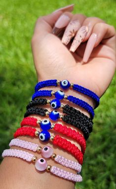 a woman's hand holding several bracelets with evil eyes and beads on them