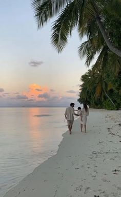 two people walking on the beach holding hands