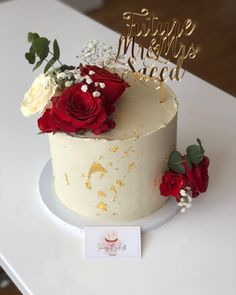 a white cake with red roses on top and happy new year's eve sign