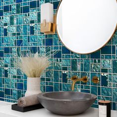 a bathroom sink sitting under a mirror next to a wall mounted faucet with a round mirror above it