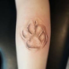 an animal paw tattoo on the right arm and left leg is shown in black and white