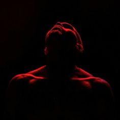 the silhouette of a man with his head turned to the side, in red light