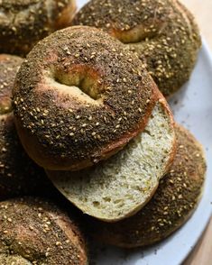 bagels piled on top of each other on a white plate with sprinkled seeds