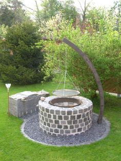 an outdoor fire pit in the middle of some grass