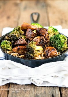 broccoli, chicken and rice in a skillet on top of a wooden table