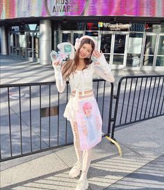 a woman posing for the camera in front of a building