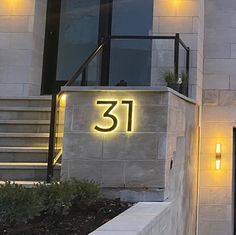 the number 31 is lit up in front of a building with stairs and lights on it