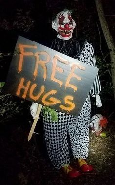 a creepy clown holding a free hugs sign