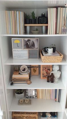 a white book shelf filled with books and pictures