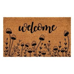 a welcome mat with mushrooms and plants on the front, in black lettering that says welcome