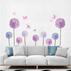 a living room filled with furniture and lots of purple flowers on top of a white wall