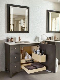 a bathroom with two sinks and a mirror above the sink is open to reveal an empty drawer underneath it