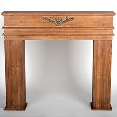 an antique wooden fireplace surround with carvings on the top and sides, made of wood