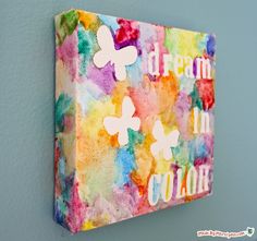 a colorful painting hanging on the wall with words written in white and pink letters that read, dream in color