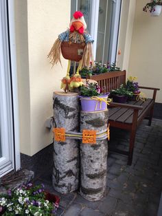 a couple of logs sitting on top of each other in front of a building next to a wooden bench