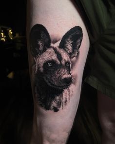 a black and white tattoo of a dog's face on the right arm,