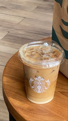 a starbucks drink sitting on top of a wooden table