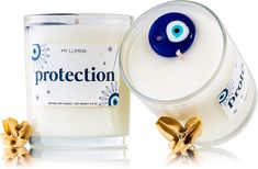 a candle with an evil eye on it next to a glass container that says protection