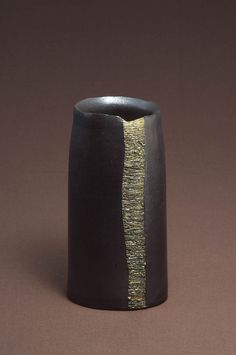 a black and gold vase sitting on top of a table