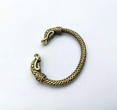 a gold bracelet with an elephant's head on the clasp and a snake's tail