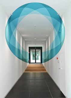 an empty hallway with blue and white circles on the wall