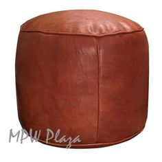 a brown leather ottoman sitting on top of a white floor